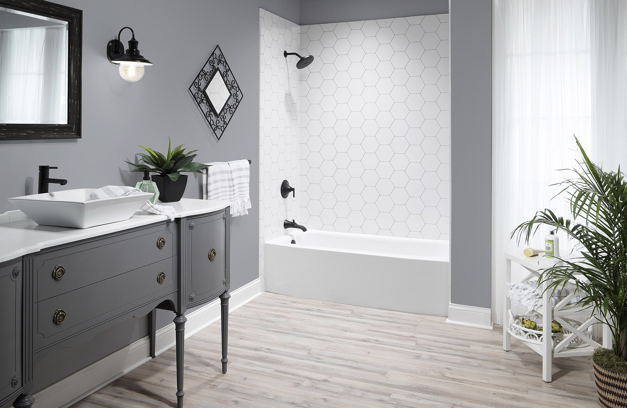 Replacement bathtub and surround seen with the vanity and mirror in frame