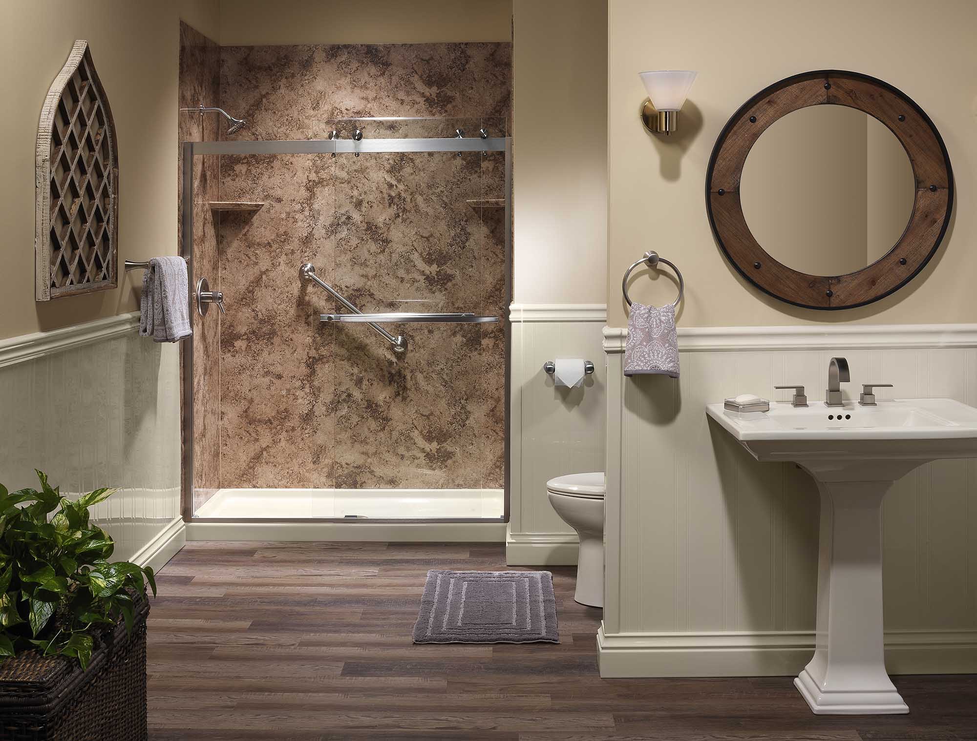 Walk-in shower with a pale marble-pattern surround, glass doors and a recessed shelf